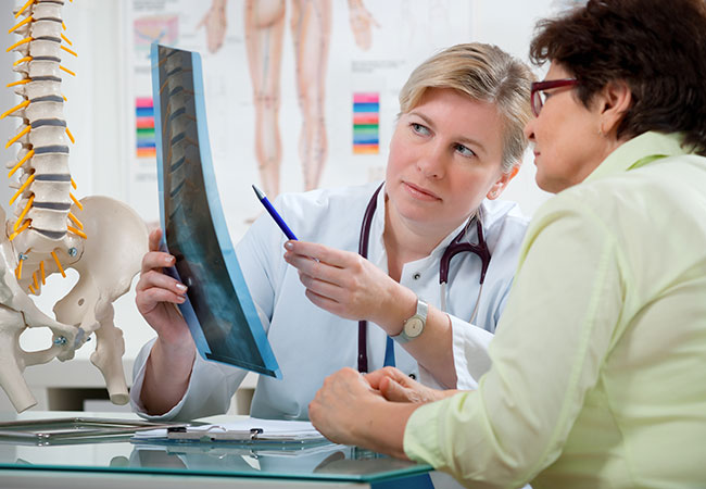 Physician with patient reviewing x-ray results