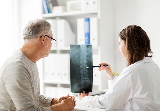 Physician with patient reviewing spine xray